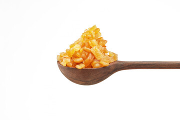 Wooden spoon with a pile of candied fruits on a white background. Shallow depth of field