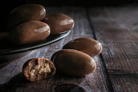 Milk Chocolate Covered Nuts On A Black Plate And Over A Rustic Wooden Table Macro Dark Food Photography Horizontal Side View Shot