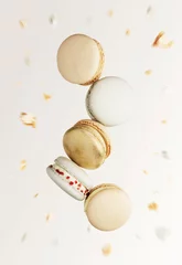 Poster White, yellow, gold macaron cookies. Colorful, sweet small French macaroon cakes. Light beige blurred background with broken macaron cuts, bits, bitten parts. Five cookies in the center of photo © Lena Ivanova