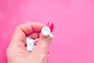 hands holding ring holder for drop of glue for eyelash extensions 