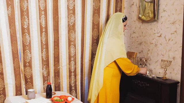 A Chabad Jewish woman in a wig and a head covering on the eve of Pesach, which coincides with Saturday, lights candles.