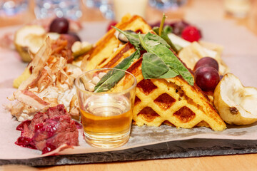 Appetizing Viennese waffles with fresh fruit on a serving plate. Close-up.