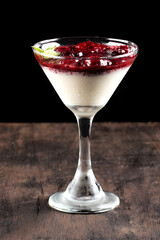 red fruit dessert, raspberry sauce, strawberry with cream and jam served in a glass bowl