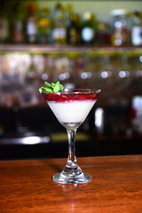 red fruit dessert, raspberry sauce, strawberry with cream and jam served in a glass bowl