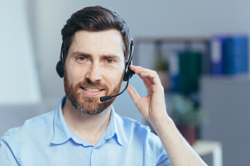 Close-up portrait of a businessman with a headset for a video call, a man looking at the camera...