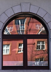 Herderbau in Freiburg spiegelt sich in einem Fenster