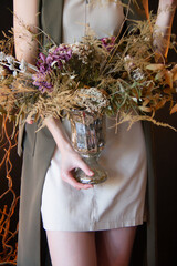 girl holds a vase with artificial flowers in her hands. close-up
