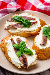 sandwich with anchovy fillet on a tray for serving on a wooden rustic background