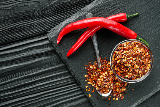 spicy chili flakes on a dark stone background