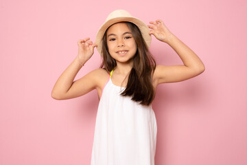 Portrait pretty girl in straw hat looking at camera isolated over pink background.