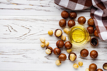 fresh macadamia nuts on a white wooden rustic background