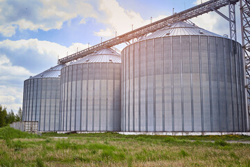 Fototapeta na wymiar Metal elevator (grain silo) in agriculture zone. Grain Warehouse or depository is an important part of harvesting. Сorn, wheat and other crops are stored in it