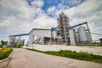 Fototapeta na wymiar Metal elevator (grain silo) in agriculture zone. Grain Warehouse or depository is an important part of harvesting. Сorn, wheat and other crops are stored in it