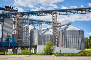 Fototapeta premium Metal elevator (grain silo) in agriculture zone. Grain Warehouse or depository is an important part of harvesting. Сorn, wheat and other crops are stored in it