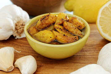 Preserved garlic in oil with spices in bowl. Indian cuisine food.