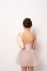 Fototapeta na wymiar Little ballerina girl in a tutu. Adorable child dancing classical ballet in a white studio.