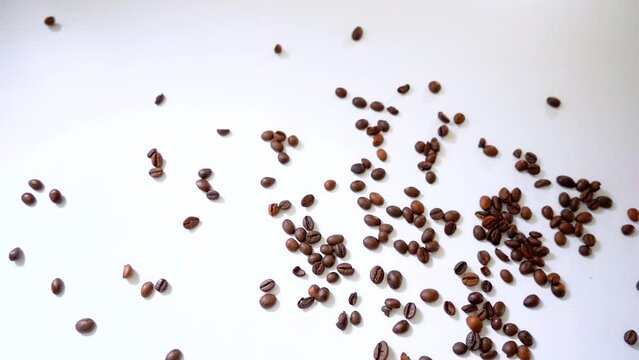coffee beans falling on a white background in slow motion 