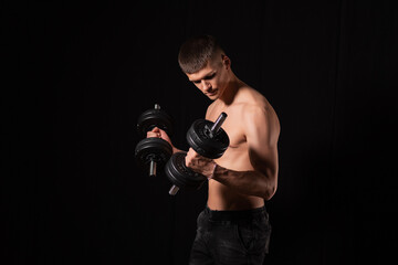 Fototapeta na wymiar Portrait of a muscular man lifting weights against a dark background