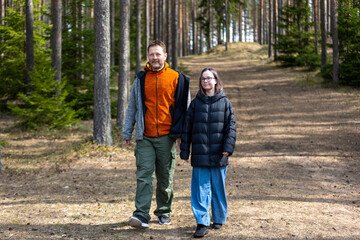 Young happy family father and daughter during a walk in the spring park. Portrait dad with child together. Family holiday in garden or forest