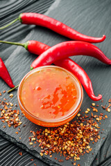 sweet chili sauce on a black wooden rustic background