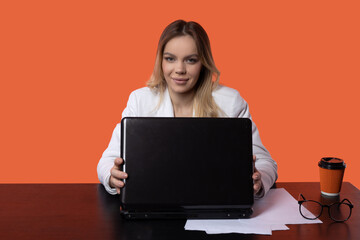 cute caucasian female in a suit at a table with a laptop