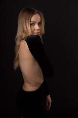 Naklejka premium sensual tender beautiful female in black dress with open back 