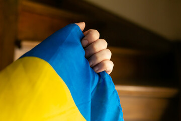 hand with small ukrainian flag wooden stairs