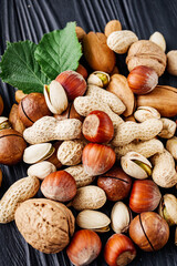 set of different nuts on a black rustic wooden background