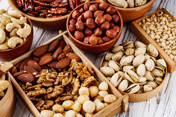 set of different nuts on a white wooden rustic background