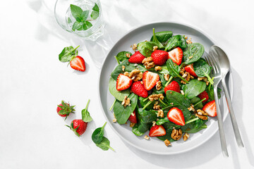 Strawberry and spinach salad with walnuts, top view - 501802483