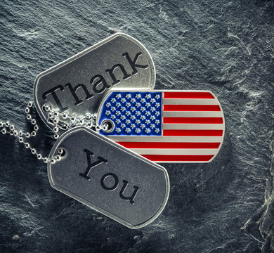 US military soldier's dog tags engraved with Thank You text and in the shape of the American flag. Memorial Day or Veterans Day concept.