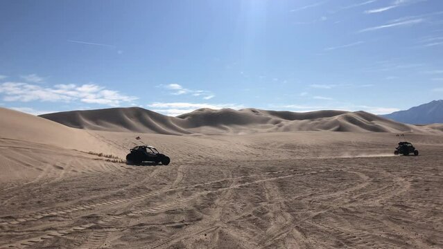 Dumont Dunes. Group of people drive on buggies at the dunes in California. High quality 4k footage