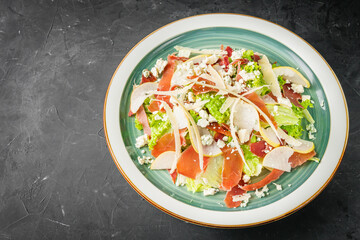 prosciutto salad with parmesan pear and blue cheese on a black background