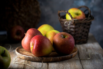 Apples with large drops of water lying in a wooden plate