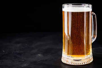 mug of beer and a set of dry fish snacks on a dark background