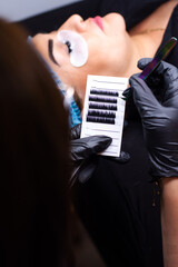 Close up of a person picking up eyelashes extensions for permanent make up