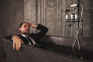 Fototapeta na wymiar Depressed young man mental health in bathtub in bathroom at home