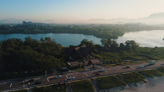 Aerial view of Reserva beach, Marapendi lagoon and car traffic on Lucio Costa avenue. Barra da Tijuca and Recreio, in Rio de Janeiro, Brazil. Sunrise. Sunny day. Drone take. Praia da Reserva.