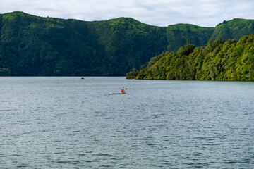 Amazing View over the Seven Cities Lake "Lagoa das Sete Cidades" with canoeing sports activities in the water, with green mountain in the background, S&atilde;o Miguel Island in the Azores, Portugal