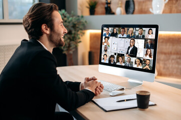 Online video conference. Caucasian business man, sit in office in front of a computer, holding a financial briefing with group of multiracial coworkers, discussing financial strategy, analyzing risks
