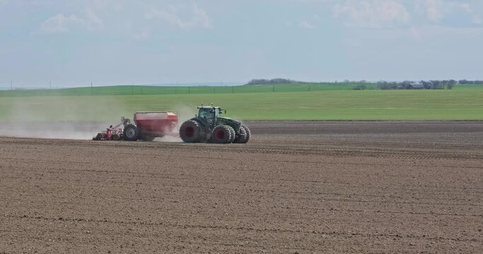 tractor cultivator or seeder plows the land, prepares for crops. dust on field