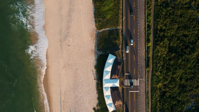 Aerial view of Reserva beach, Marapendi lagoon and car traffic on Lucio Costa avenue. Barra da Tijuca and Recreio, in Rio de Janeiro, Brazil. Sunrise. Sunny day. Drone take. Praia da Reserva.