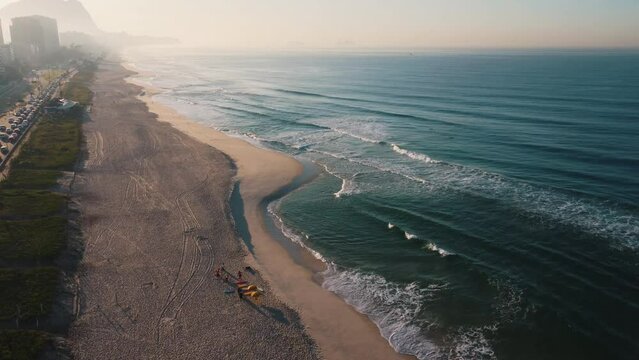 Aerial view of Reserva beach, Marapendi lagoon and car traffic on Lucio Costa avenue. Barra da Tijuca and Recreio, in Rio de Janeiro, Brazil. Sunrise. Sunny day. Drone take. Praia da Reserva.