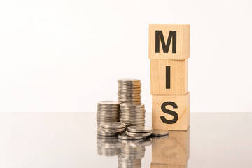MIS - text on wooden cubes on white background with coins © Maks_Lab