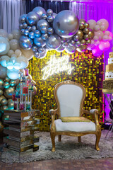 happy birthday sobre silla en evento social con globos dorados 