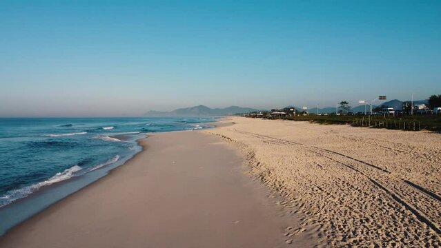 Aerial view of Reserva beach, Marapendi lagoon and car traffic on Lucio Costa avenue. Barra da Tijuca and Recreio, in Rio de Janeiro, Brazil. Sunrise. Sunny day. Drone take. Praia da Reserva.