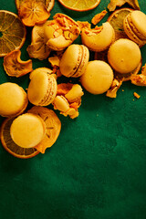 Macaroons with pieces of dried fruit are on the green background. High quality photo