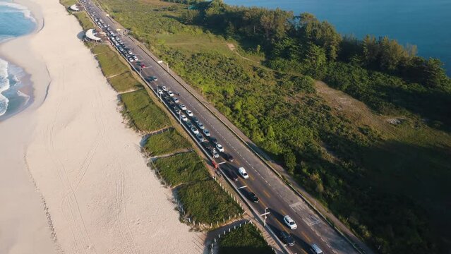 Aerial view of Reserva beach, Marapendi lagoon and car traffic on Lucio Costa avenue. Barra da Tijuca and Recreio, in Rio de Janeiro, Brazil. Sunrise. Sunny day. Drone take. Praia da Reserva.