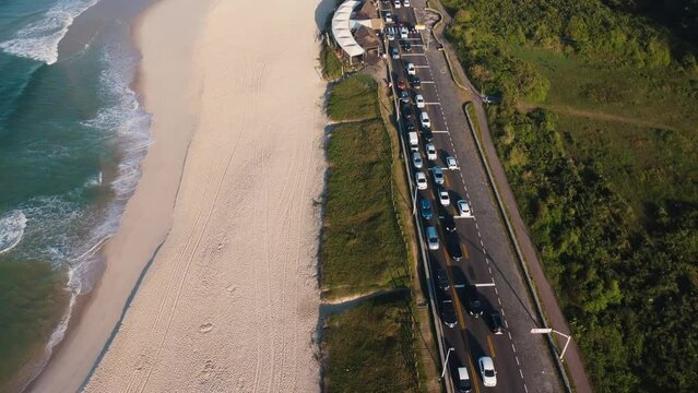 Aerial view of Reserva beach, Marapendi lagoon and car traffic on Lucio Costa avenue. Barra da Tijuca and Recreio, in Rio de Janeiro, Brazil. Sunrise. Sunny day. Drone take. Praia da Reserva.