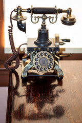 Fototapeta na wymiar Antique Phone Sits on a Wood Desk